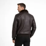 Rear view of black leather aviator jacket showing fur collar, shoulder epaulets, clean back panel, ribbed hem, classic bomber construction