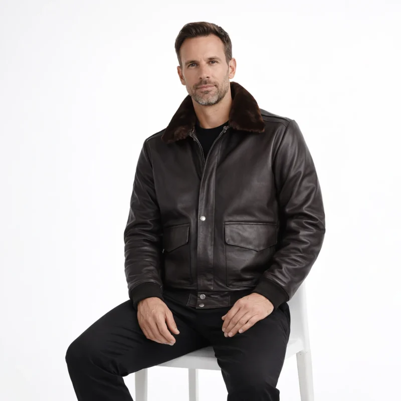 Man seated wearing black leather aviator jacket showing comfortable fit, luxurious fur collar, functional chest pockets, practical cold weather wear