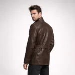 Rear view of brown leather field jacket showing smooth back panel, belted waist, shoulder seam detailing, and hip-length cut