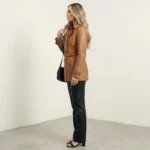 Side view of caramel leather trench jacket for women showing belted waist and double-breasted structure