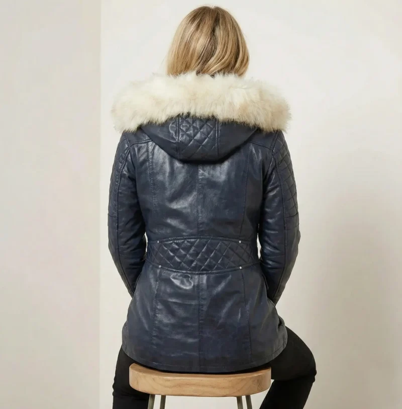 Back view of women’s navy leather winter coat with fur hood and quilted sleeve detail