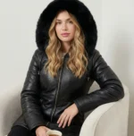 Woman wearing black leather winter coat with fur hood and front zipper closure, front view