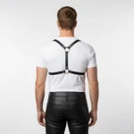Back view of black leather chest harness with X-back strap design and adjustable center buckle