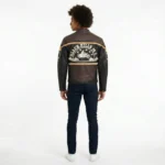 Back view of Black Hills Sturgis genuine leather biker jacket showing dark brown shoulder yoke, black leather back panel, tan stripe and sleeve patches
